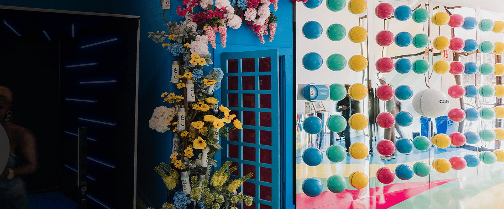 Colorful pop-up installation featuring floral decorations and vibrant spheres, showcasing Core Water branding, designed for experiential marketing by GEOEVENTS.