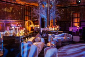 Elegant event space with modern lounge seating, ambient lighting, and decorative floral arrangements, designed for corporate gatherings and holiday celebrations.